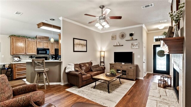 living room featuring visible vents, a high end fireplace, ceiling fan, and wood finished floors