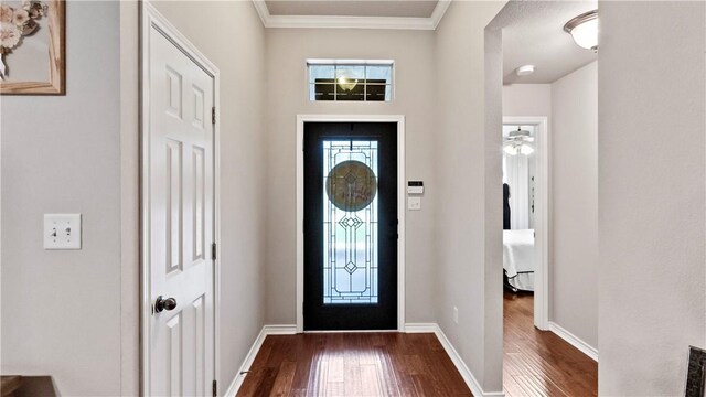 foyer with baseboards, ornamental molding, and dark wood-type flooring