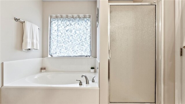 bathroom with a shower stall and a bath