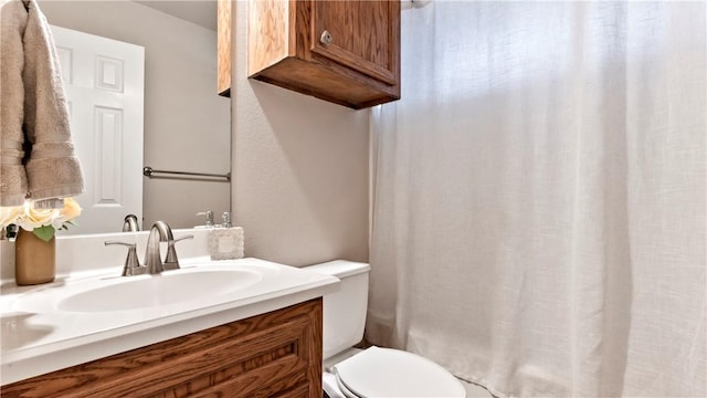 bathroom featuring toilet, a shower with curtain, and vanity