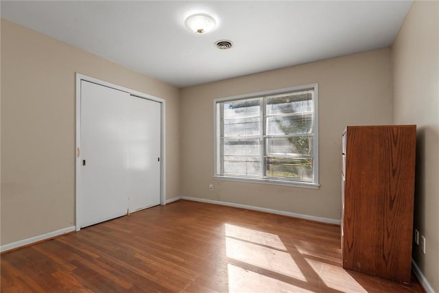 unfurnished bedroom featuring a closet and hardwood / wood-style flooring