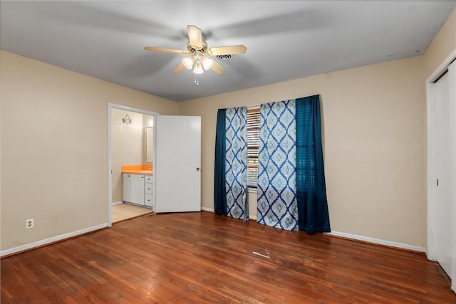 interior space with hardwood / wood-style flooring, ceiling fan, and ensuite bath