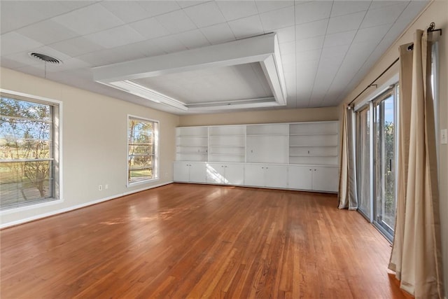 unfurnished bedroom with wood-type flooring and multiple windows