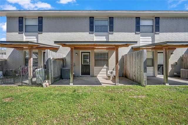 back of property featuring a patio, brick siding, and fence