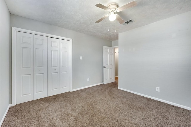 unfurnished bedroom with baseboards, visible vents, carpet, a textured ceiling, and a closet