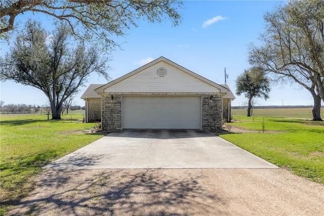 view of front of property with a front yard, stone siding, and a detached garage