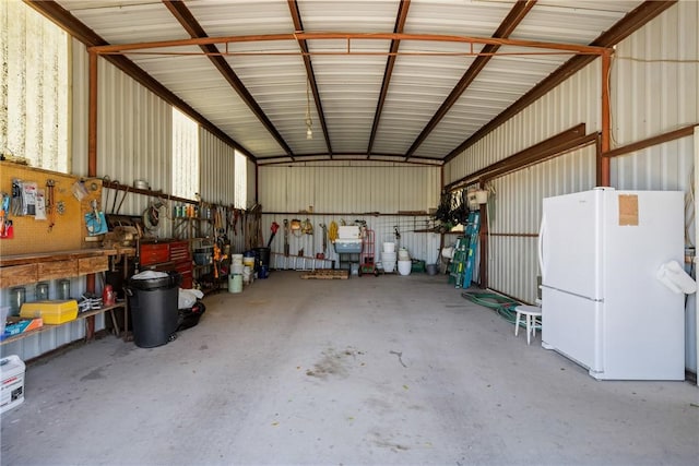 garage with metal wall and freestanding refrigerator