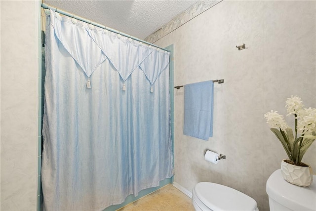 full bathroom with a shower with shower curtain, toilet, a textured ceiling, and tile patterned flooring