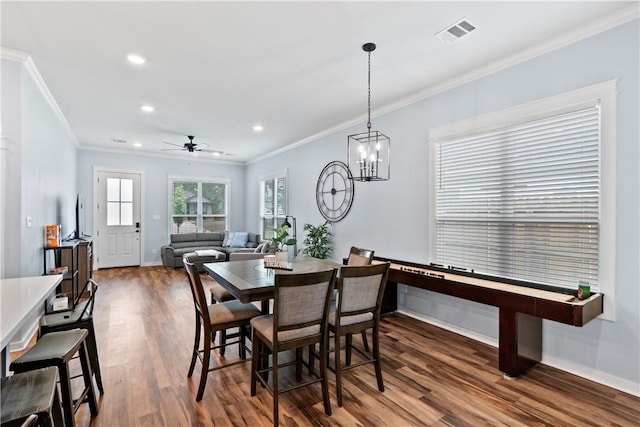 dining space featuring crown molding, recessed lighting, baseboards, wood finished floors, and visible vents