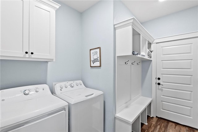 clothes washing area with cabinet space, dark wood finished floors, and washing machine and clothes dryer