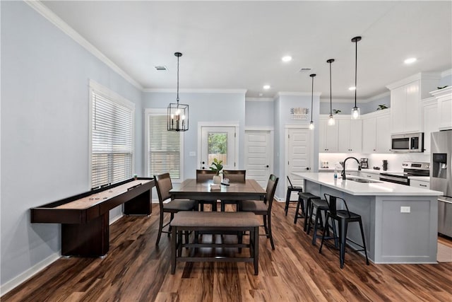 dining room with crown molding, dark wood finished floors, and visible vents