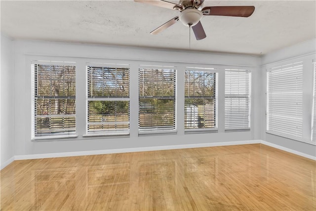 unfurnished sunroom featuring a wealth of natural light and ceiling fan