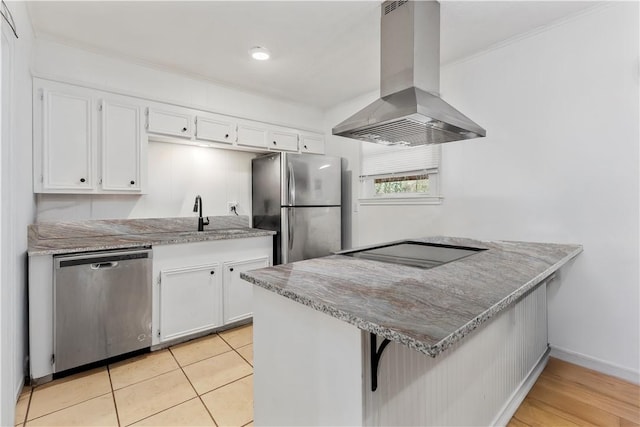 kitchen with white cabinetry, stainless steel appliances, island range hood, a kitchen bar, and kitchen peninsula