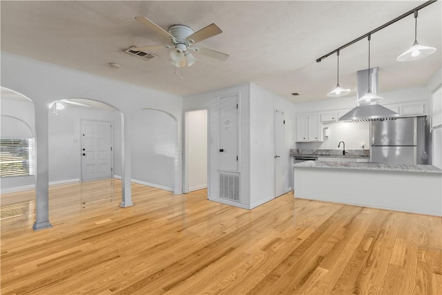 kitchen featuring pendant lighting, stainless steel fridge, white cabinets, ceiling fan, and light hardwood / wood-style floors