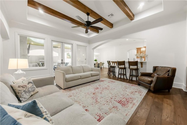 4231 Villaggio Ct, Bryan, TX 77802 - living area with arched walkways, wood finished floors, ceiling fan, beam ceiling, and a chandelier