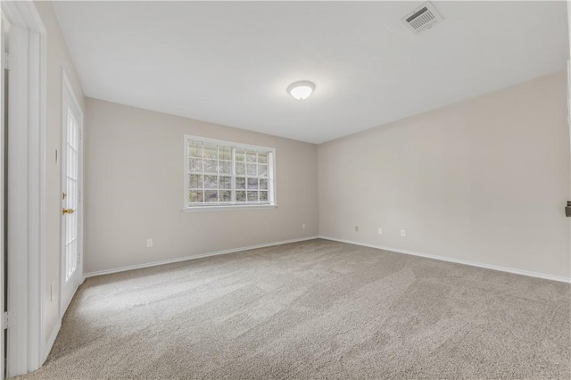 spare room featuring carpet floors, baseboards, and visible vents