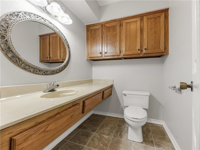 bathroom with toilet, baseboards, tile patterned floors, and vanity