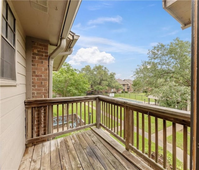 wooden terrace with a lawn and fence