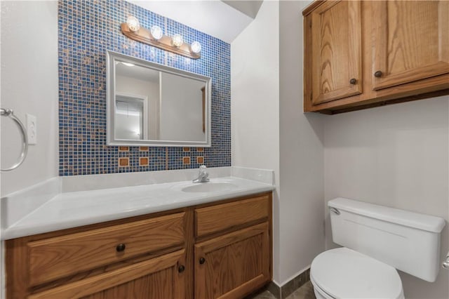 bathroom featuring backsplash, toilet, baseboards, and vanity