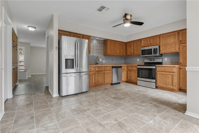 kitchen with visible vents, light countertops, a ceiling fan, backsplash, and stainless steel appliances