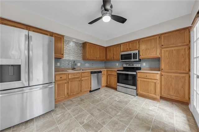 kitchen featuring a sink, light countertops, backsplash, and stainless steel appliances