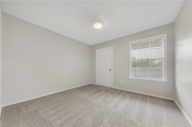 unfurnished room with carpet floors and baseboards