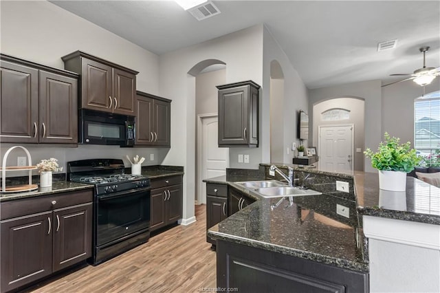 kitchen featuring dark brown cabinetry, sink, light hardwood / wood-style flooring, and black appliances