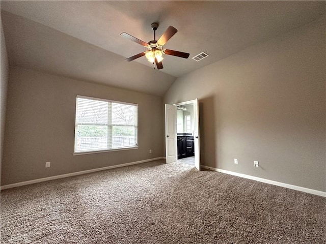 empty room with ceiling fan, light colored carpet, visible vents, baseboards, and vaulted ceiling