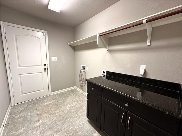 clothes washing area featuring cabinet space, hookup for a washing machine, electric dryer hookup, and baseboards