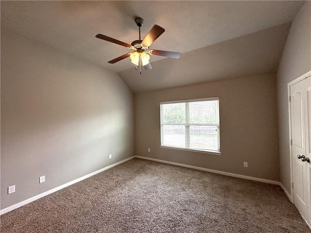 carpeted empty room featuring vaulted ceiling, ceiling fan, and baseboards