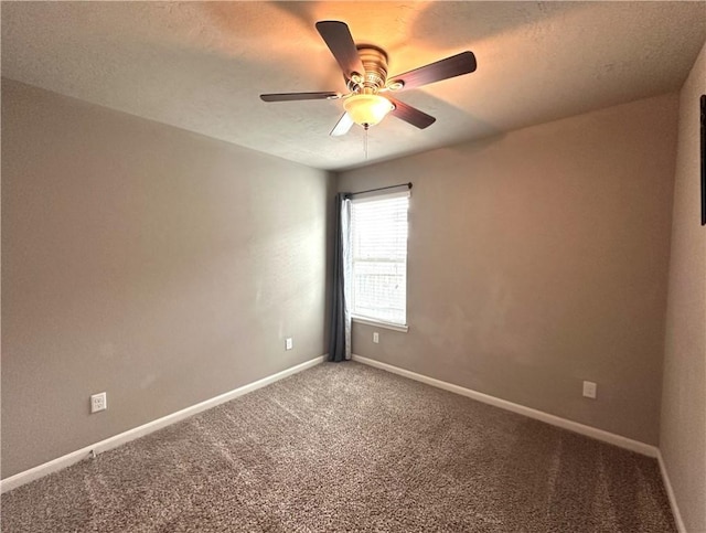 spare room with carpet floors, a ceiling fan, and baseboards