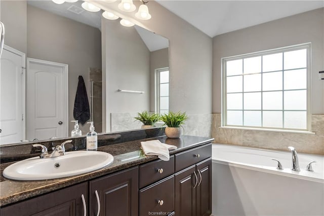 bathroom with a tub to relax in and vanity