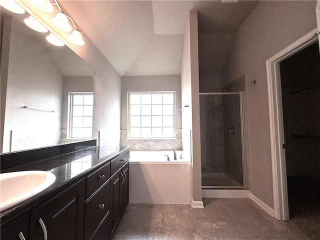 full bathroom featuring double vanity, a stall shower, a garden tub, vaulted ceiling, and a sink