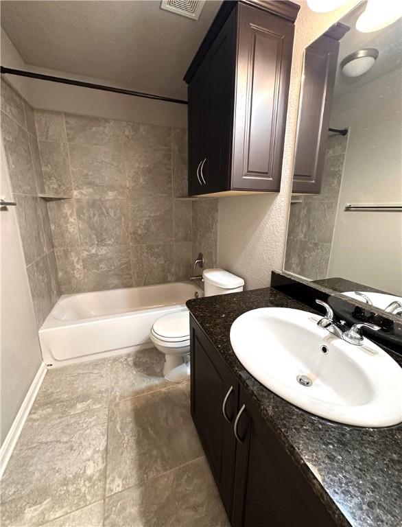 bathroom featuring bathing tub / shower combination, toilet, and vanity