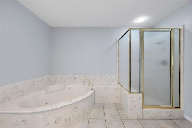 bathroom with tile patterned floors and tiled bath