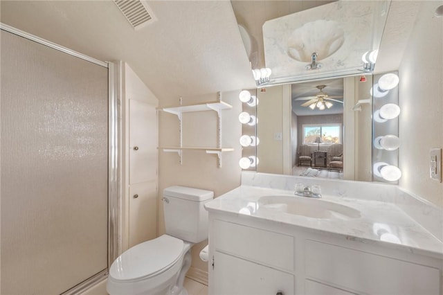 bathroom with an enclosed shower, vanity, toilet, and ceiling fan