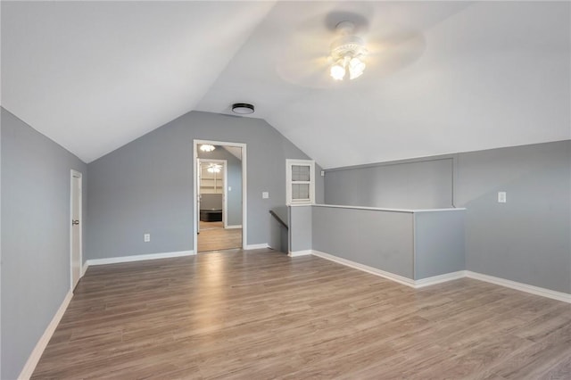 additional living space featuring hardwood / wood-style flooring, vaulted ceiling, and ceiling fan