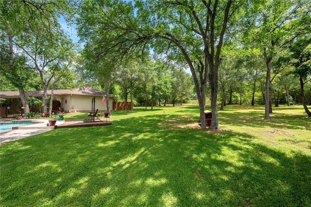 view of yard featuring a deck, an outdoor pool, and fence