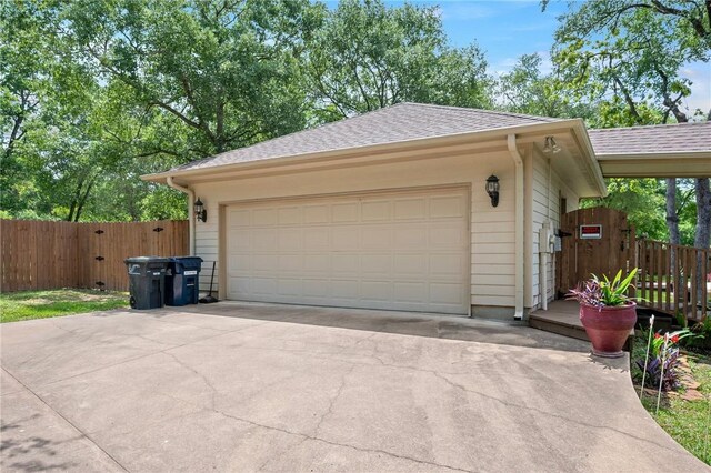 garage featuring fence and driveway