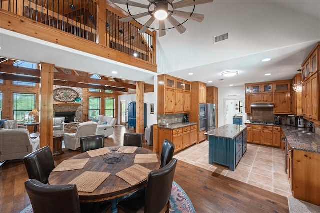 dining room with recessed lighting, light wood-style floors, ceiling fan, a stone fireplace, and visible vents