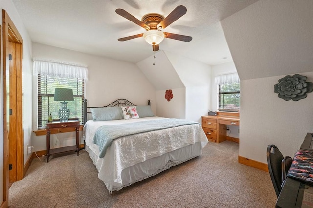 bedroom featuring lofted ceiling, light colored carpet, and baseboards