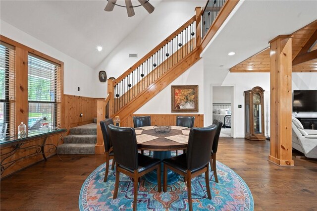 dining space with dark wood-style floors, stairs, wooden walls, recessed lighting, and wainscoting
