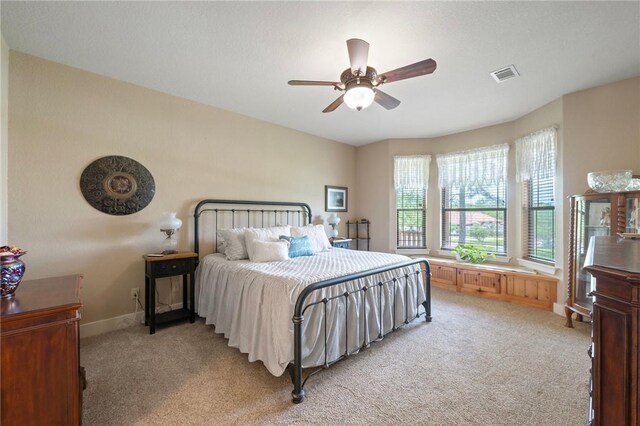 bedroom featuring visible vents, ceiling fan, baseboards, and light carpet
