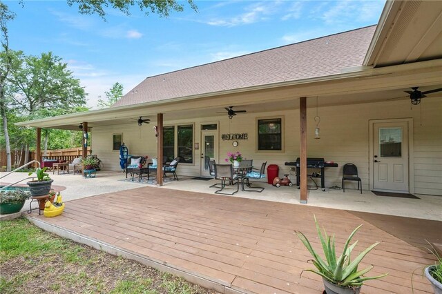 wooden terrace featuring a ceiling fan, outdoor dining area, and fence