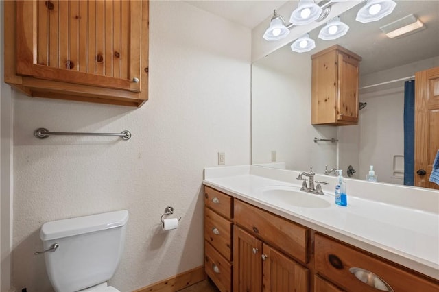 bathroom with vanity, toilet, a shower with curtain, and baseboards