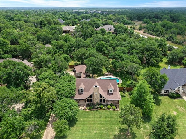 bird's eye view with a wooded view