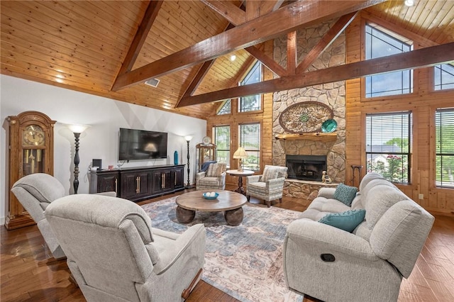 living area with wood ceiling, hardwood / wood-style flooring, high vaulted ceiling, and a stone fireplace