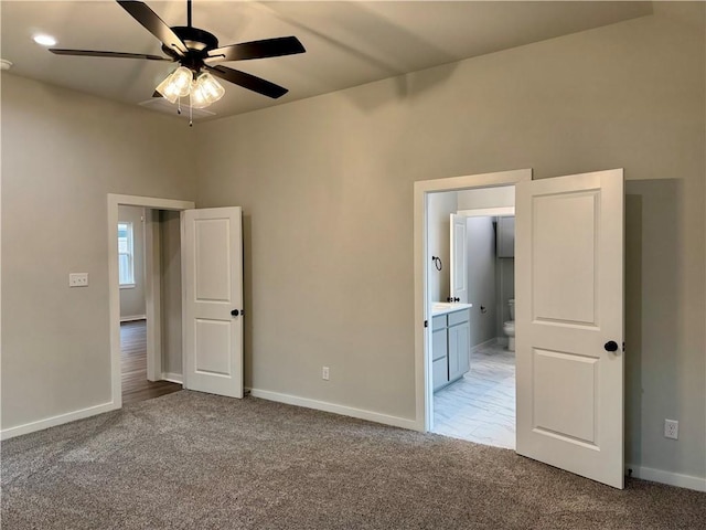 unfurnished bedroom featuring connected bathroom, ceiling fan, and carpet floors