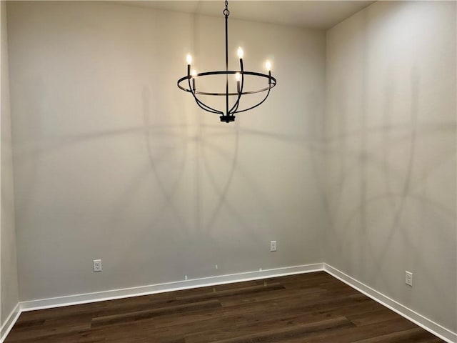 unfurnished dining area with dark hardwood / wood-style floors and a chandelier