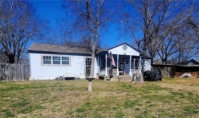 view of front of house with covered porch, fence, and a front lawn